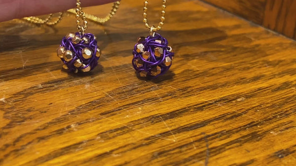 Video of Artist Ree Gallagher's 2 handmade tiny round woven nest pendants in color combination purple and gold